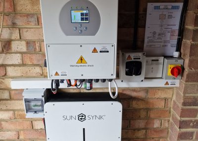 sunsynk inverter and batteries on a brick wall