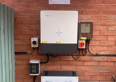givenergy inverter and battery on a brick house wall
