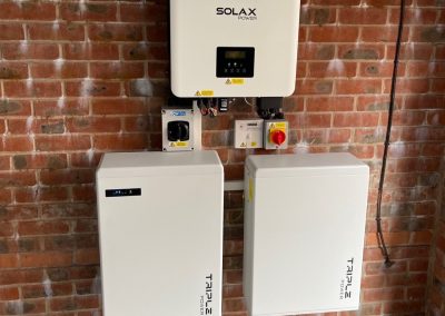 solax inverter and batteries on a red brick wall