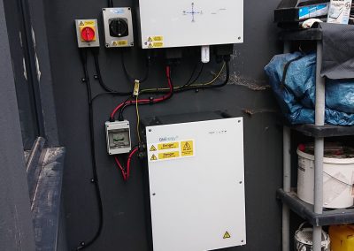 givenergy inverter and battery on a black house wall