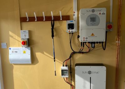 sunsynk inverter and batteries on a yellow wall