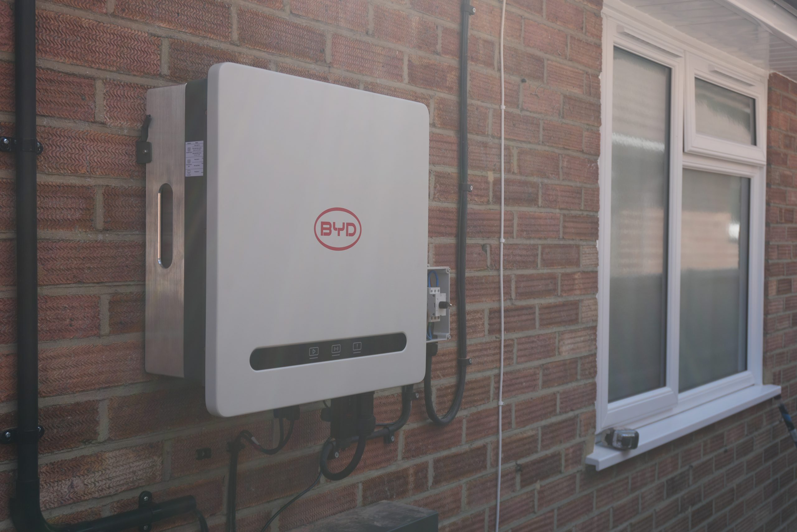 BYD Battery-Box HVE battery storage tower mounted against a brick wall