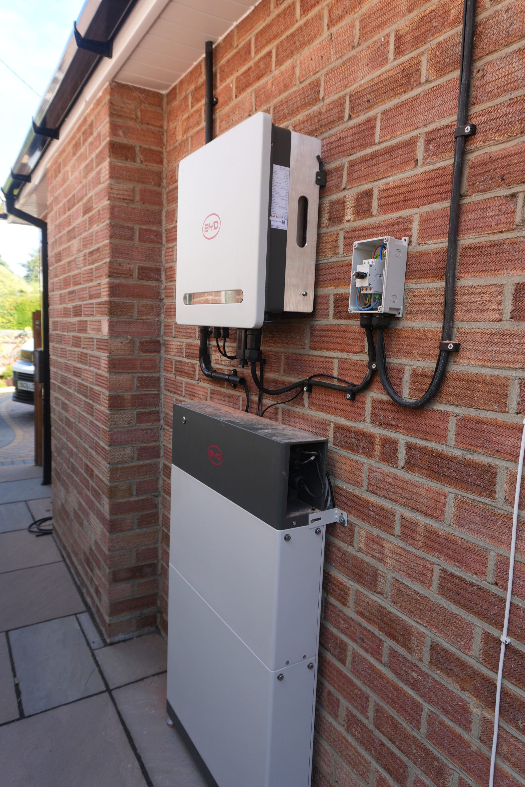 BYD Power-Box SH4.6K hybrid inverter and Battery-Box HVE storage tower installed on a house wall in West Moors, Ferndown