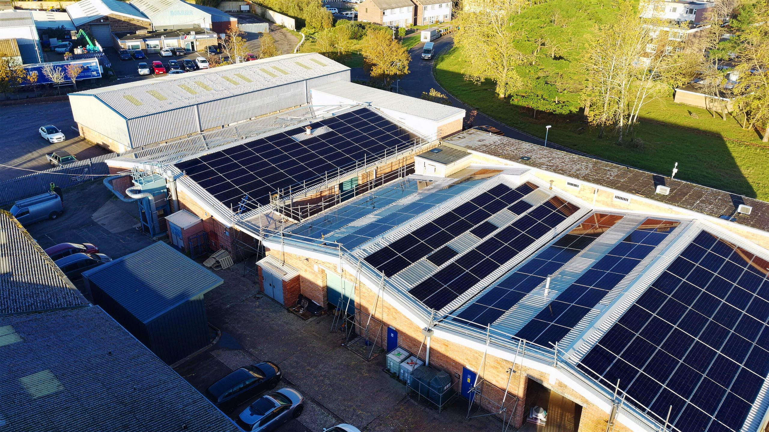 Aerial drone photo of solar panels installed across three factory roofs at TransDev, Dawkins Road, Poole, by DES Renewables